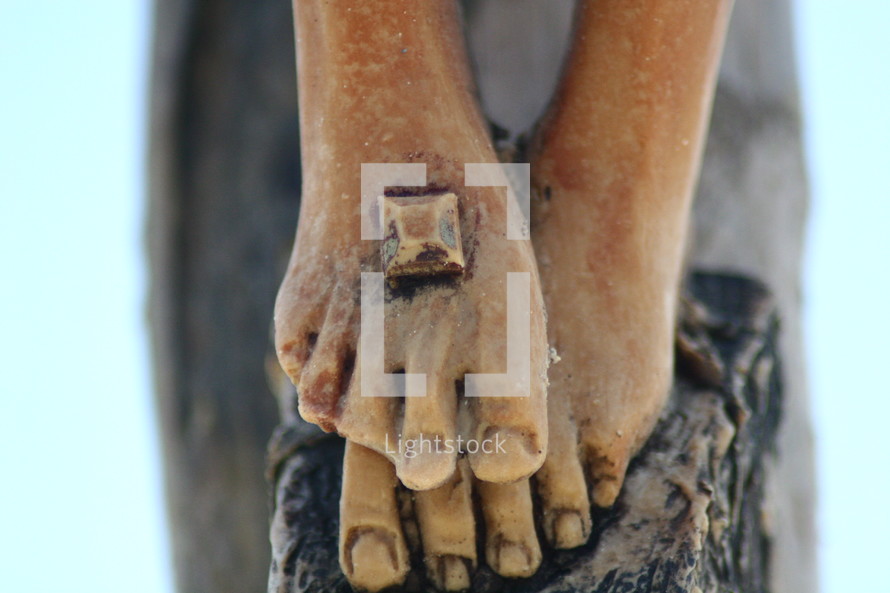 feet of a statue of Jesus with nail