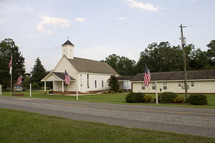 American flags flying in front of a Church 