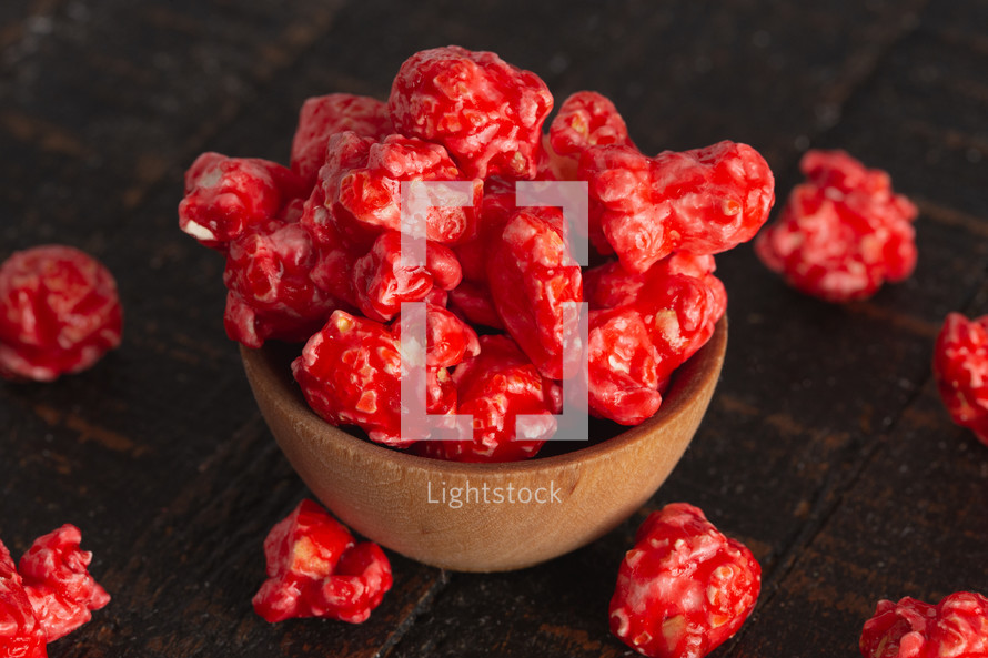 Red Cinnamon Popcorn on a Wood Background
