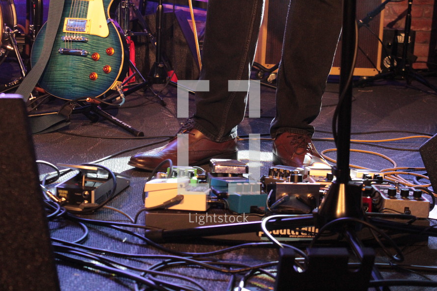 man's feet on guitar pedals 
