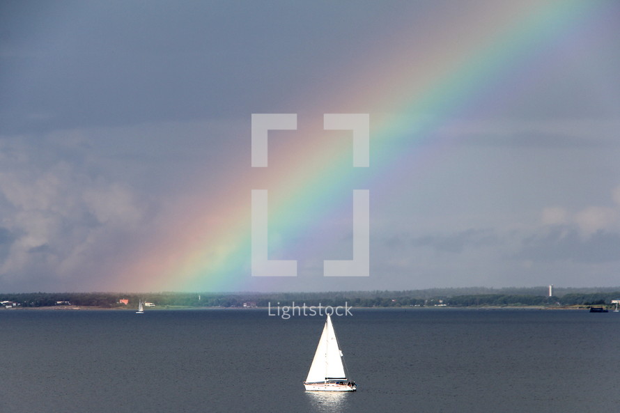 Rainbow in the sky and a sailboat on the water