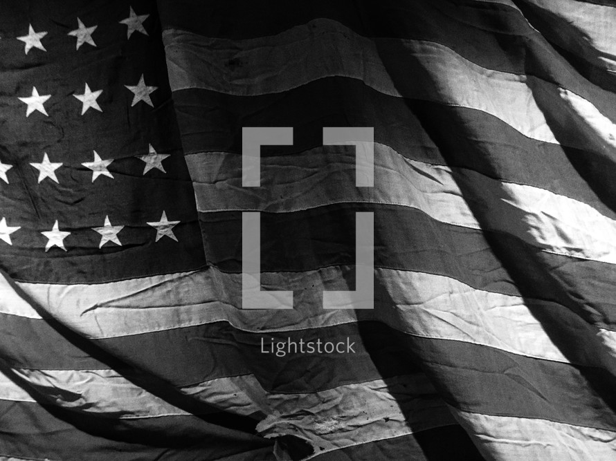 A faded old American flag in black and white.