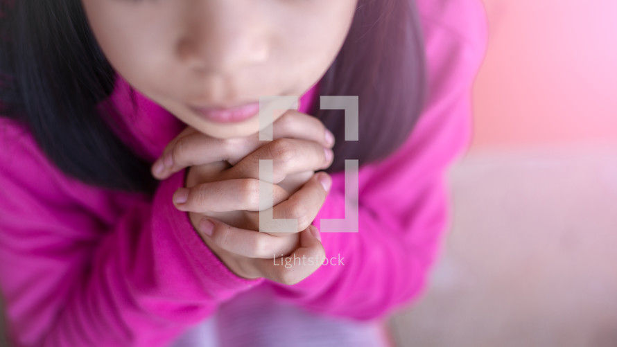 closeup of a little girl praying 