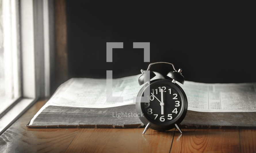 open Bible and alarm clock 