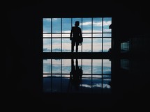 silhouette of a man standing in front of a window 