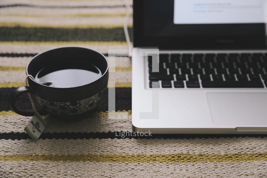 a tea cup and laptop computer 