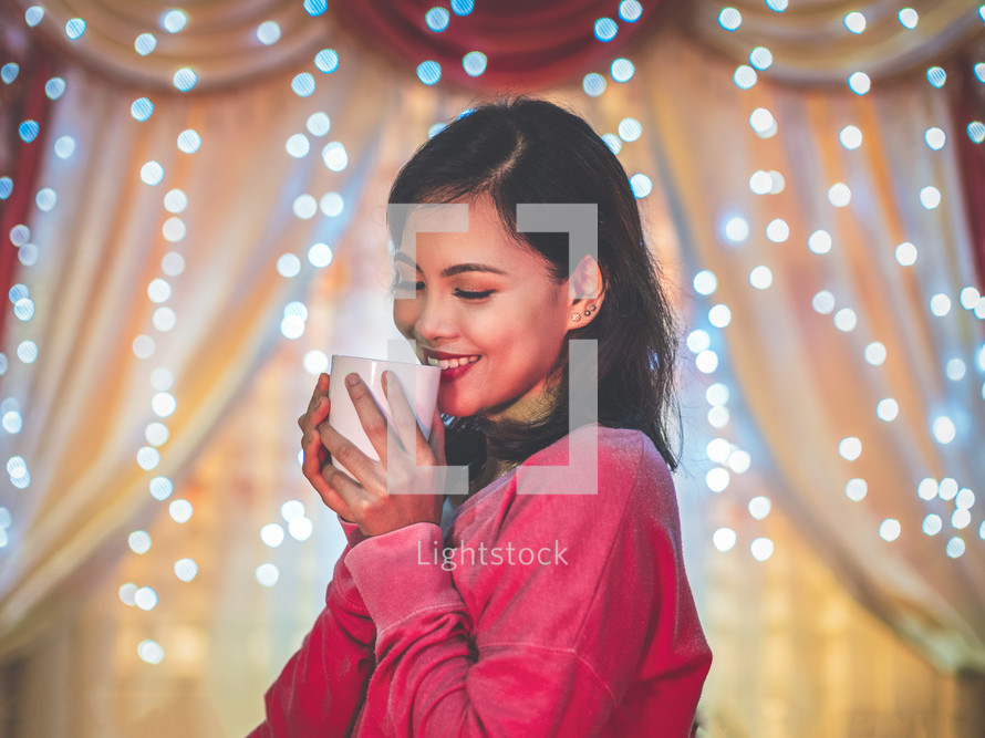 a smiling woman holding a mug 