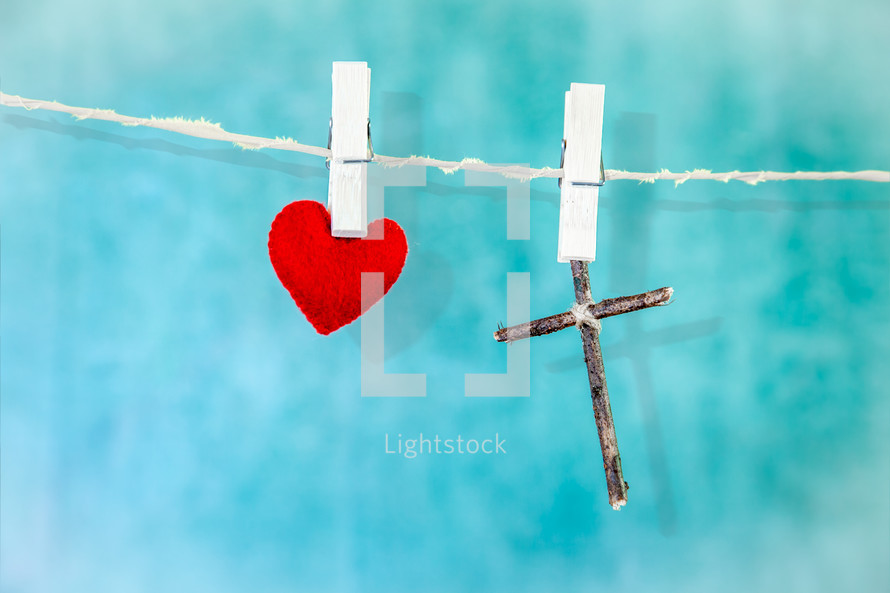 red felt heart and cross made of sticks on a clothesline 