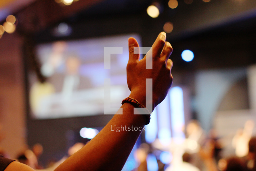a raised hand at a worship service 