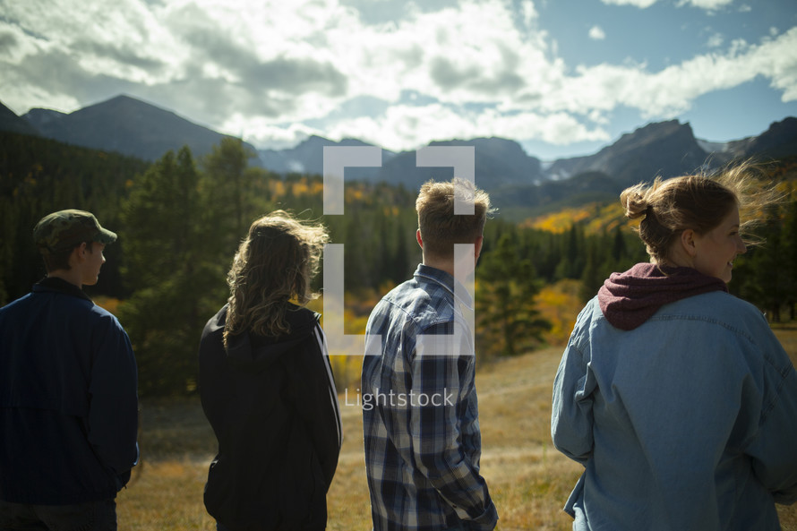 young adults standing in a valley in fall