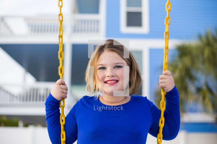 smiling preteen girl on a swing 