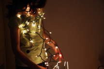 girl hanging Christmas lights 