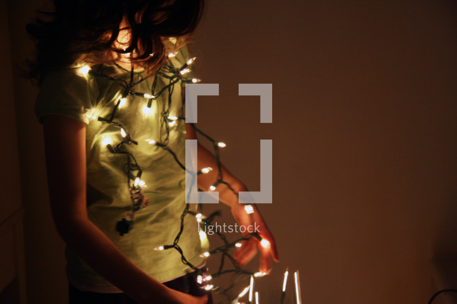 girl hanging Christmas lights 