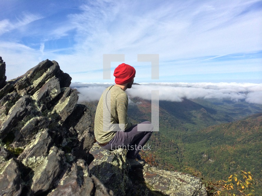 man looking out at mountains 