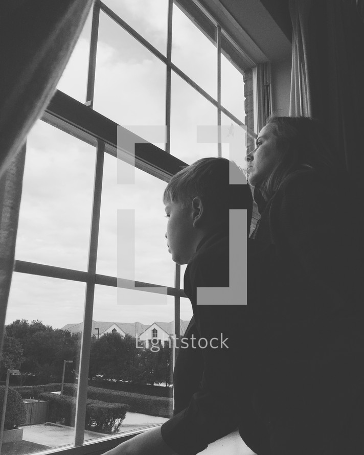 mother and son looking out a window 