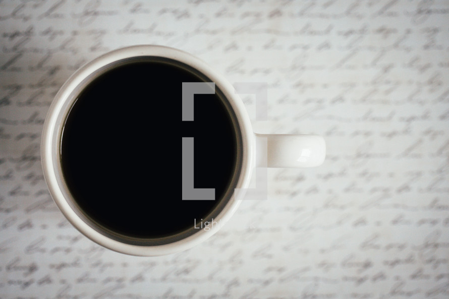 a mug of coffee on words on paper 
