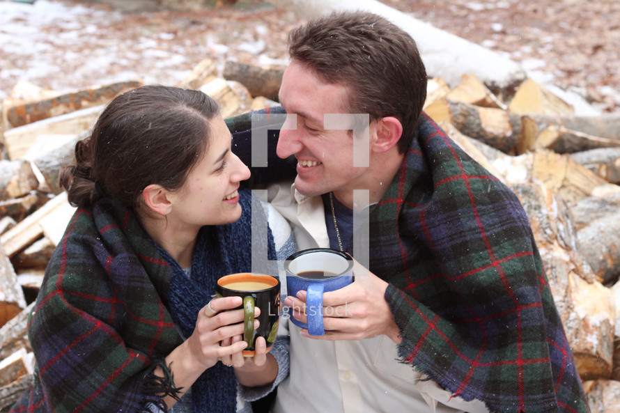 a couple snuggling drinking hot cocoa 