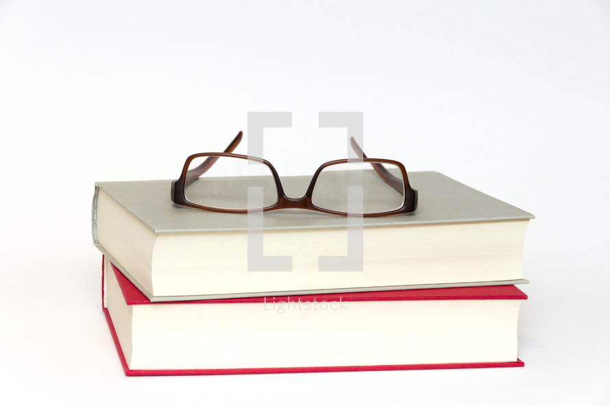 reading glasses on a stack of books 