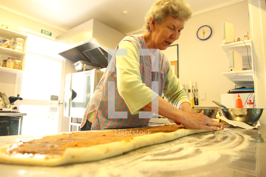 elderly woman baking in a kitchen 