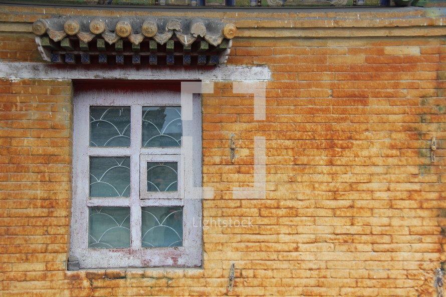 Window in a yellow brick Mongolian wall 