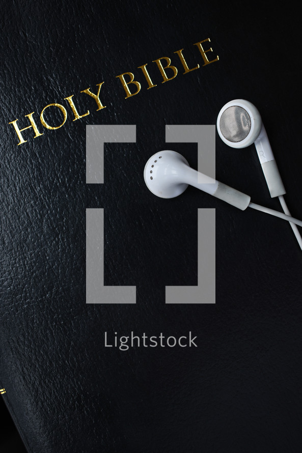 Holy Bible and earbuds 
