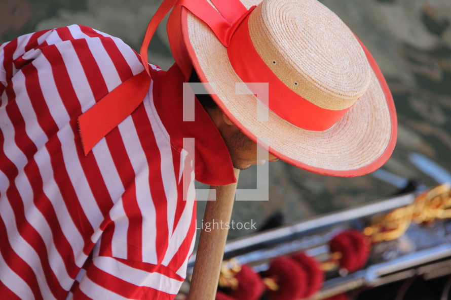Gondolier in traditional striped top, straw hat with flowing ribbon 