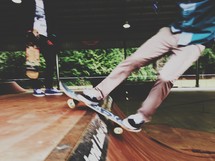 Teen boys skateboarding at a skate park. 