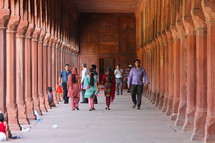 People walking through the covered walkway surrounding the Taj Mahal