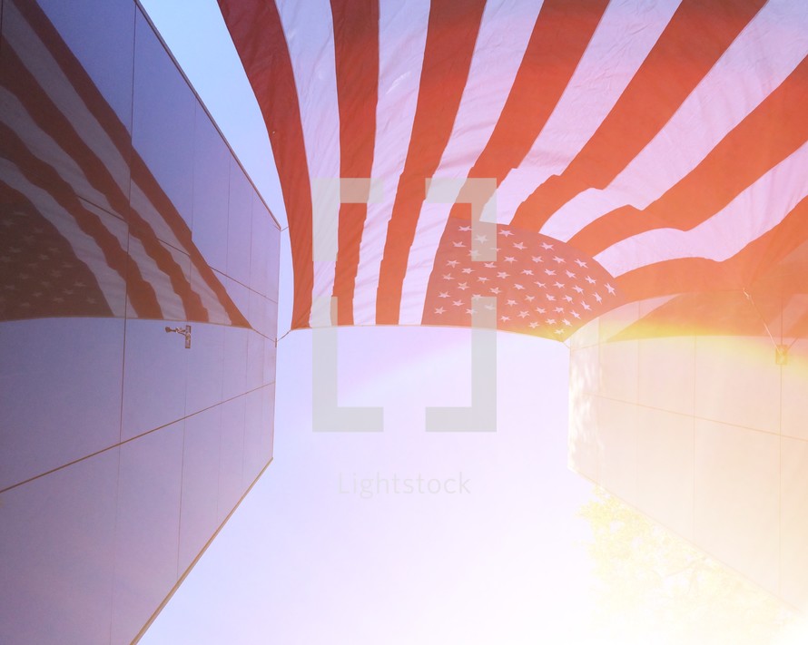 reflection of an American flag on the glass of a buildings windows 