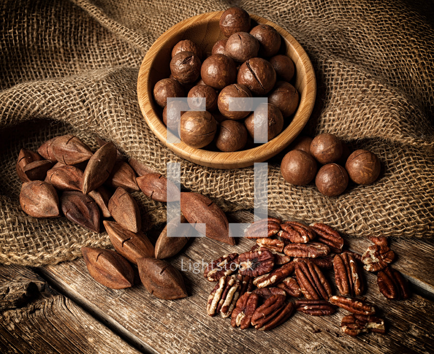 Macadamia, Pecan and Pili nuts on wooden table.