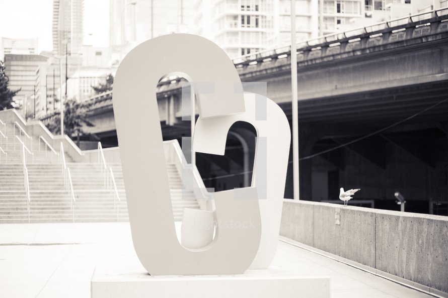Letter "C" sculpture on the platform of a subway station.