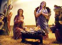 A Nativity scene featuring Baby Jesus born in the manger surrounded by Mary, Joseph, The Wise Men and an Angel glorifying Jesus admiring the child in His innocence and divinity.  