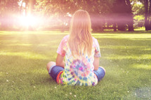 young girl sitting in the park on a sunny summer day