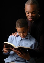 Father reading a Bible to his son