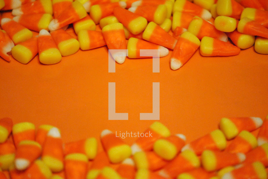 Orange surface with candy corn borders for Halloween or Thanksgiving message.