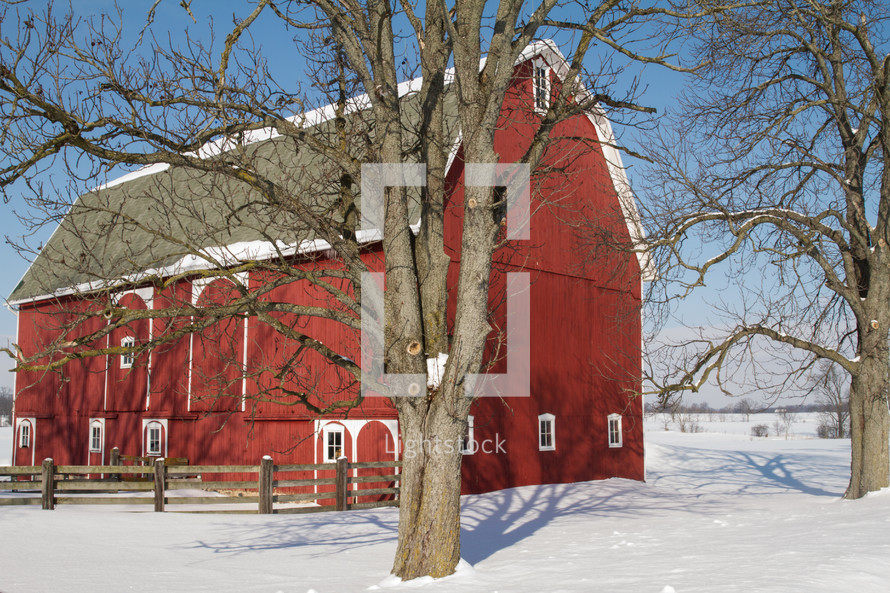 snow over a red barn 