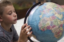 A boy studying a globe.