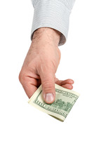 Hand holding folded hundred dollar bills.