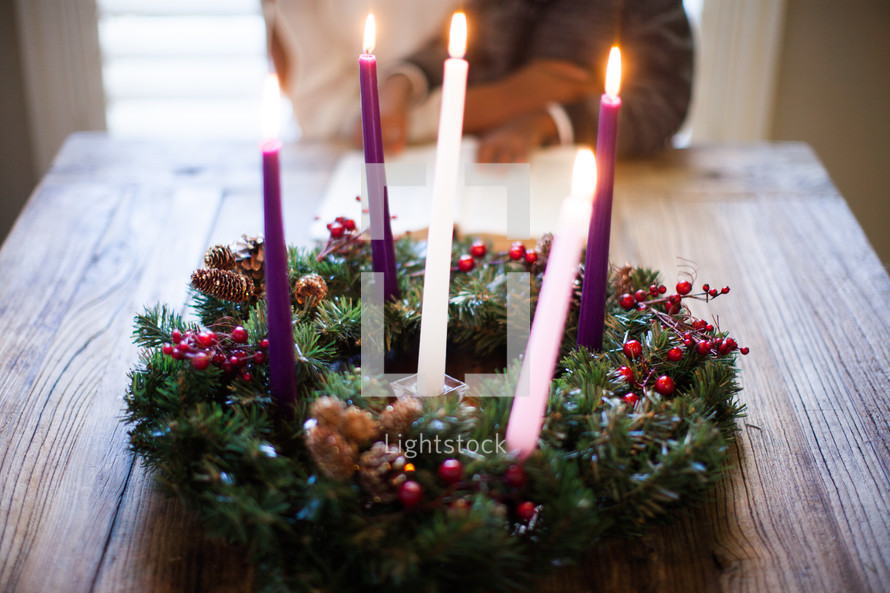 mother and son reading a Bible in front of an Advent wreath 
