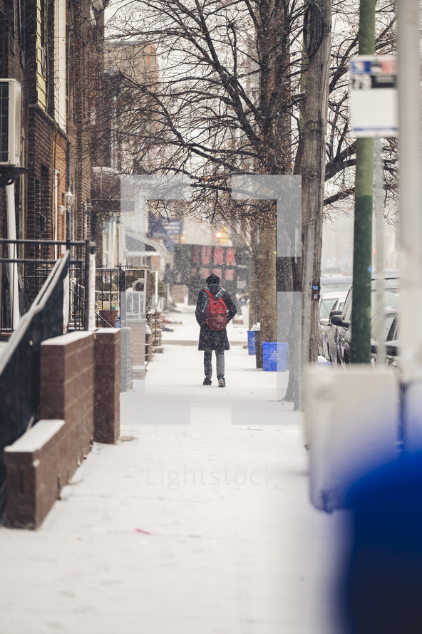 a person walking on a sidewalk in snow 