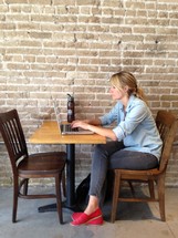 Woman with a laptop sitting in a cafe. 