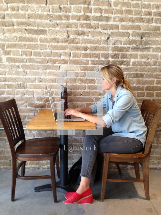 Woman with a laptop sitting in a cafe. 