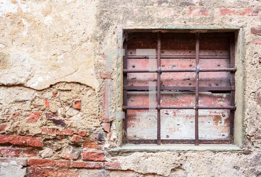 Old window with iron gratings of a house in Tuscany.