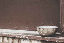 metal bowl in a window sill 