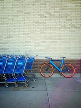 A parked bike and shopping carts. 