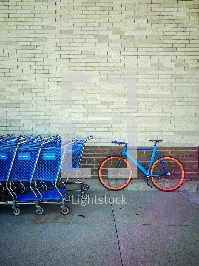 A parked bike and shopping carts. 