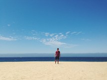 A man standing on a beach. 