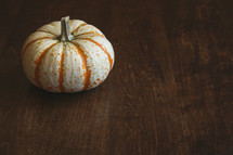 single pumpkin on a wood table