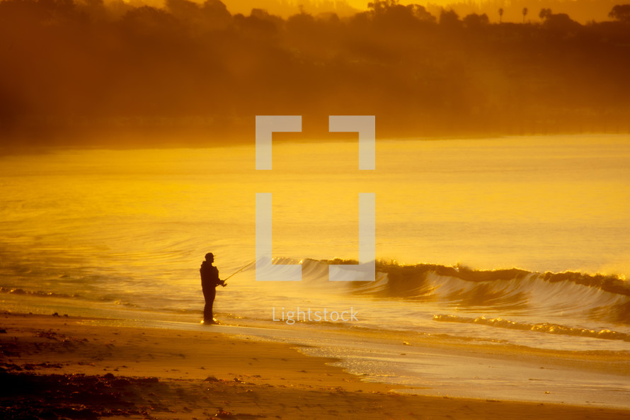 man fishing along a shore at sunset 