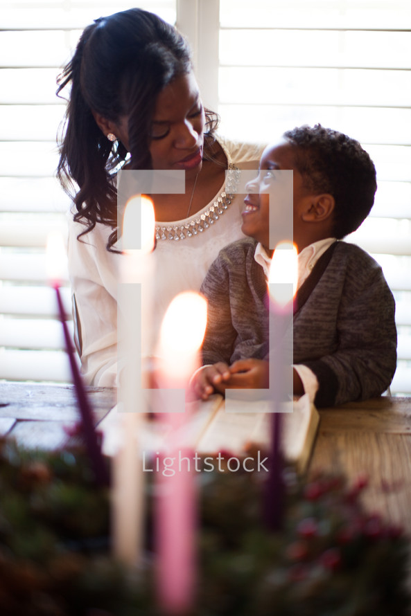 mother and son reading a Bible by an Advent wreath 